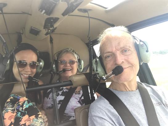 Three happy passengers create unforgettable memories on a thrilling helicopter ride.