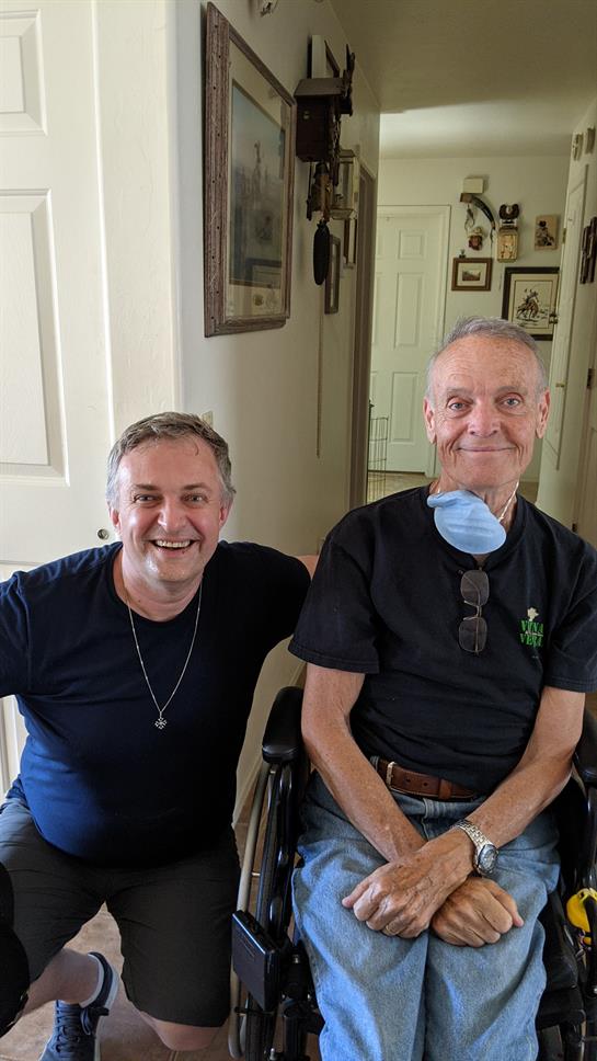 Two men smile happily while spending quality time in a welcoming home environment.