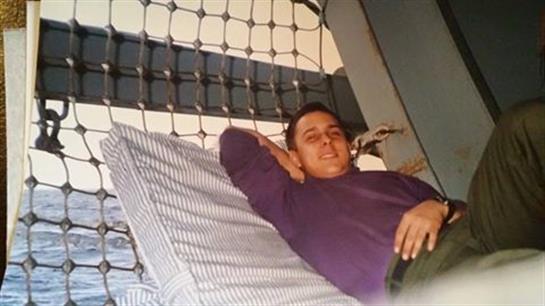 A man reclines comfortably on a bed in a modern bedroom, showcasing a creative wall design.