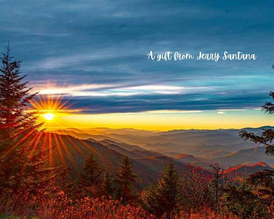 Sunlight bursts over mountains, illuminating valleys and trees during a breathtaking sunrise.