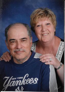 Senior couple smiles warmly together in the studio, showcasing their affection.