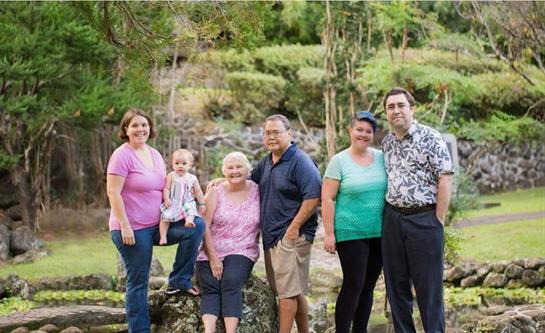Six family members pose happily in a vibrant garden, celebrating together in a joyful atmosphere.
