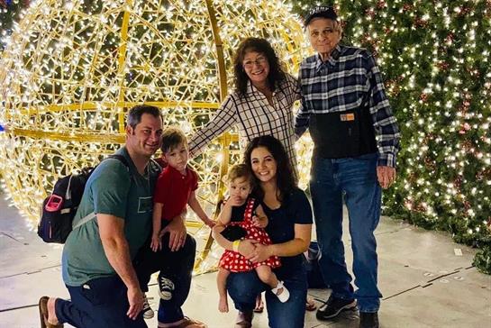 Family enjoys a joyful holiday gathering in front of dazzling lights, creating memories together.