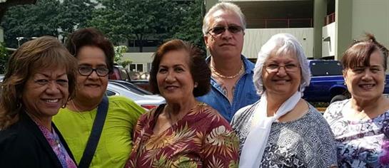 A group of friends smiles together, enjoying their time outdoors in a lively urban setting.