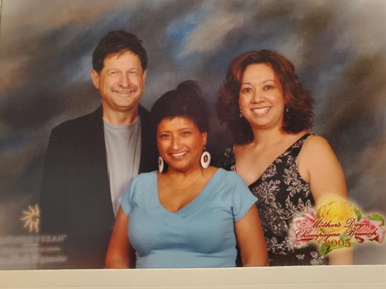 Three individuals are enjoying each other's company, posing happily in a studio environment.