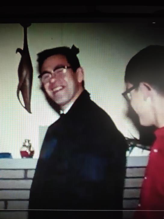 Two friends are laughing and chatting at a home gathering with cheerful decor around them.