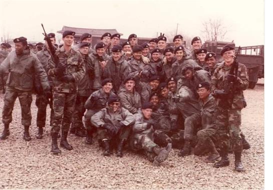 Soldiers smiling and posing together at a training site, highlighting camaraderie.