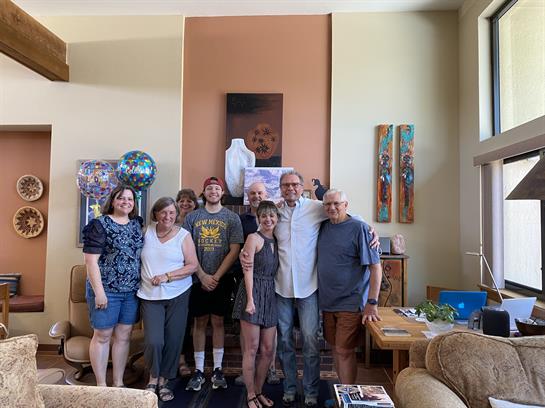 A group of family members pose together in a warm living room, enjoying quality time.