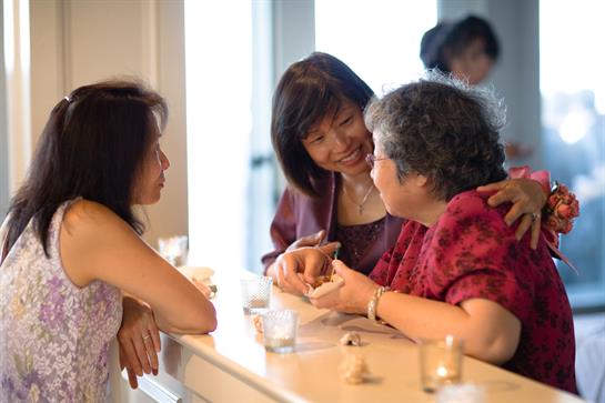 Three women engage in a lively discussion while sharing a drink at a cafe.