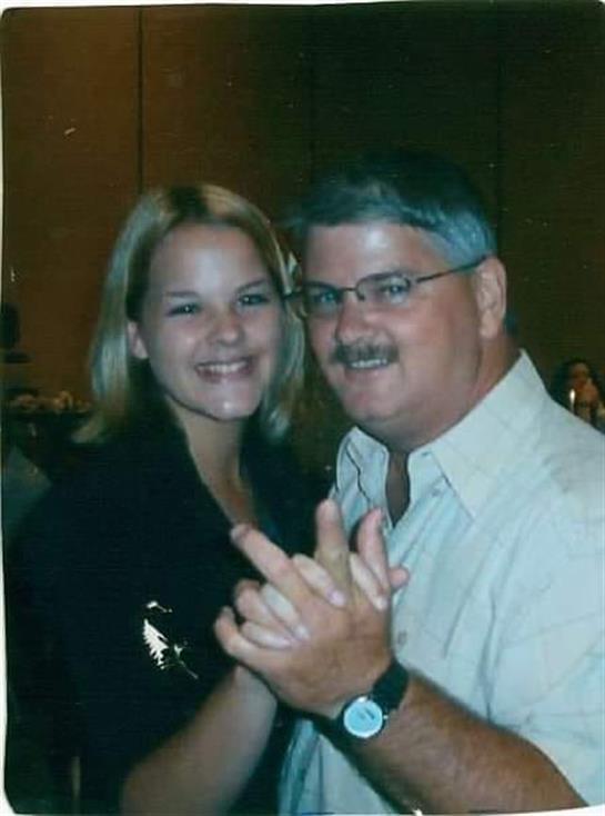 A couple enjoys dancing together at a lively event, smiling and engaging with each other happily.