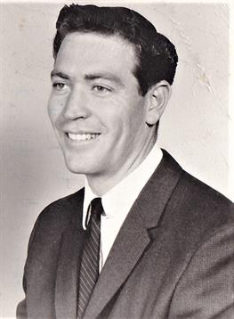 A young man dressed in formal clothes is smiling, exuding confidence and charisma.