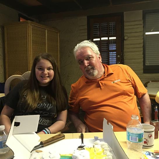 Two people share smiles at a game night, highlighting fun and joy in a cozy indoor setting.