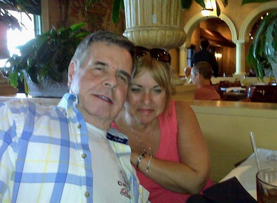 A cheerful couple sits together at a restaurant table, enjoying their time and each other's company.