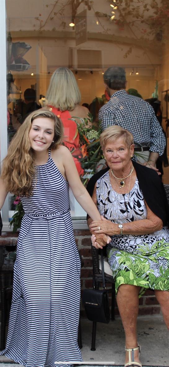 Woman and elderly lady pose together, both smiling, showcasing their close relationship and joy.