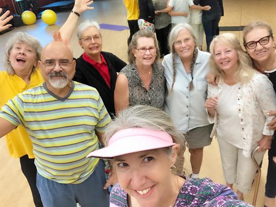 Seniors participate in a fun gathering at a community center, smiling and engaging with each other.