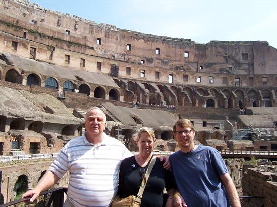 Three people enjoy their visit to the Colosseum, capturing a special moment in history.