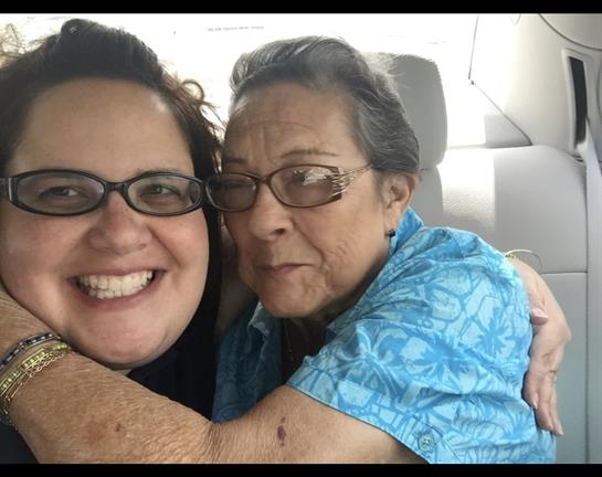 Two family members smile and hug in a vehicle, cherishing their time together.