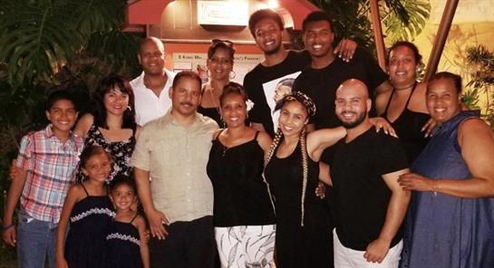 A diverse group of friends shares smiles during a cheerful evening in casual attire.