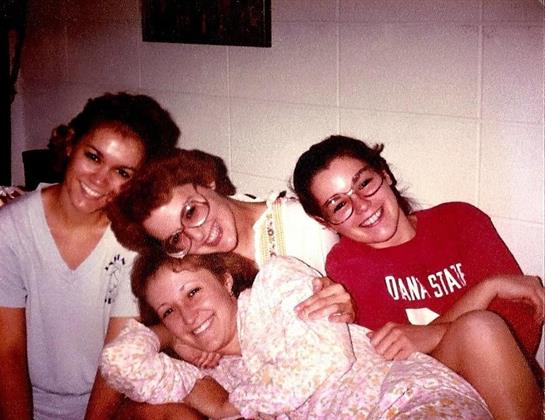 Four friends enjoy each other's company while lounging in a warm, friendly atmosphere at home.