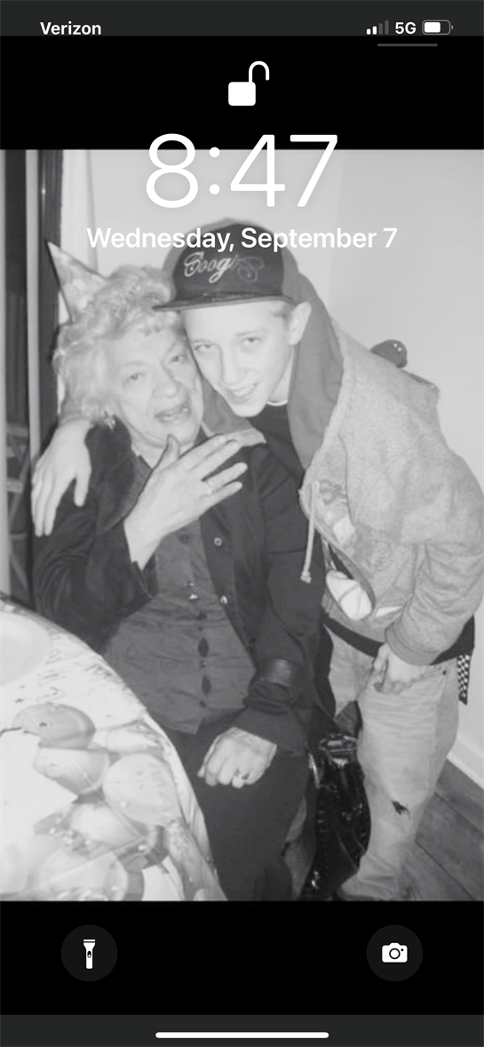 A young boy embraces his grandmother, smiling warmly in their home during a family event.
