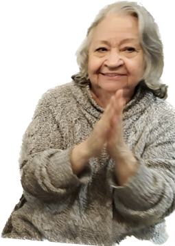 An elderly woman smiles warmly while clapping her hands, exuding joy and warmth.