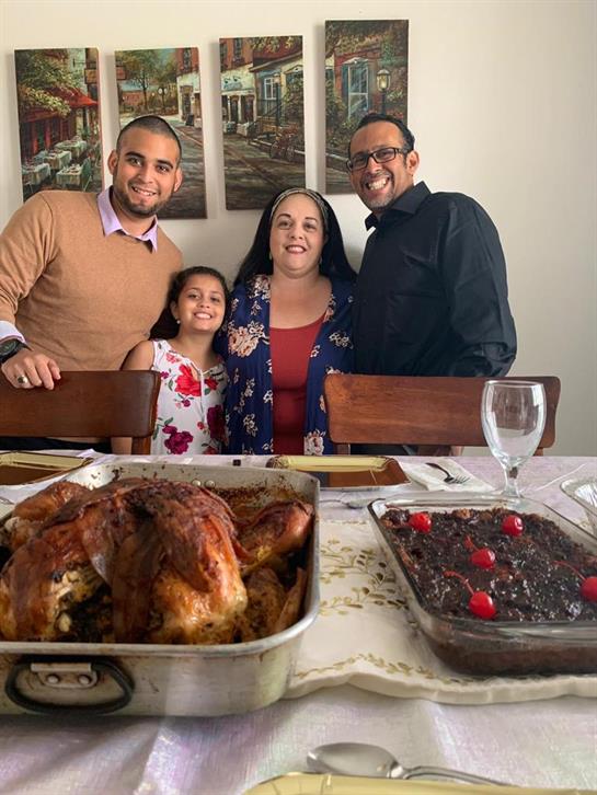 A happy family gathers around a table with delicious food, celebrating a special moment.