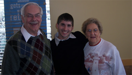 Three family members pose happily in a warm indoor environment, celebrating together.