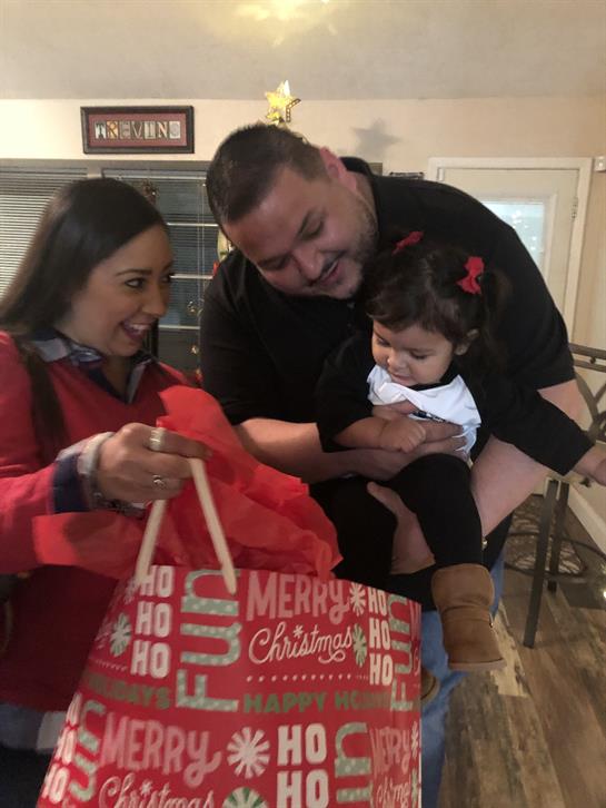 Happy family enjoys exchanging Christmas gifts with smiles and love in a warm home atmosphere.