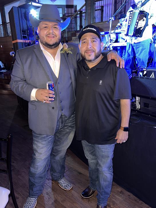 Two friends smile together, enjoying a festive night of music and celebration.