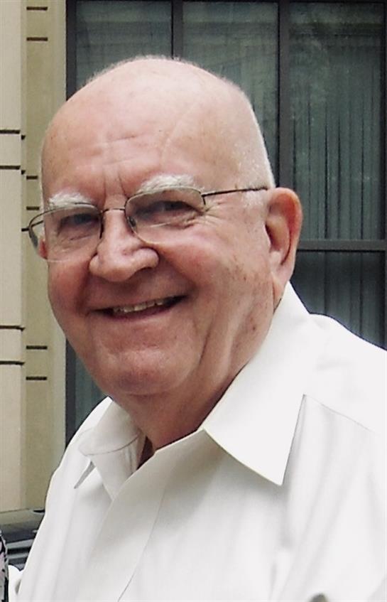 A cheerful elderly man enjoys a sunny day in the park, showcasing his friendly smile and joy.