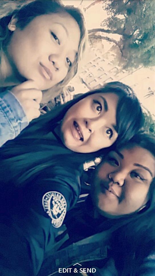 Three friends pose for a selfie, smiling and enjoying their time at an outdoor event.