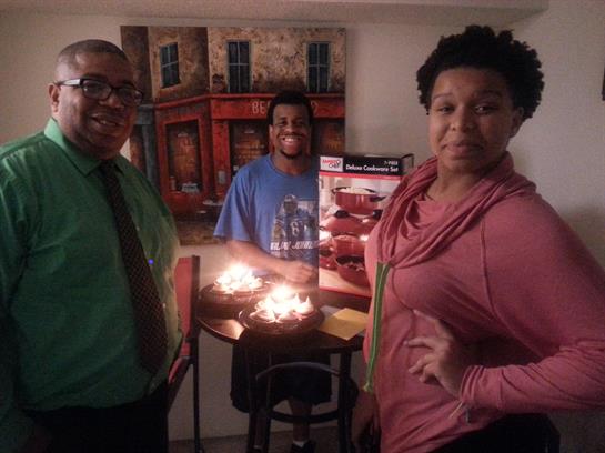 Three friends celebrate at a table with lit birthday cakes, sharing joy and smiles.
