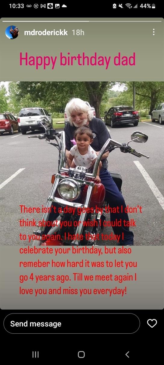 A child and grandparent pose joyfully on a motorcycle in a park while celebrating a birthday.