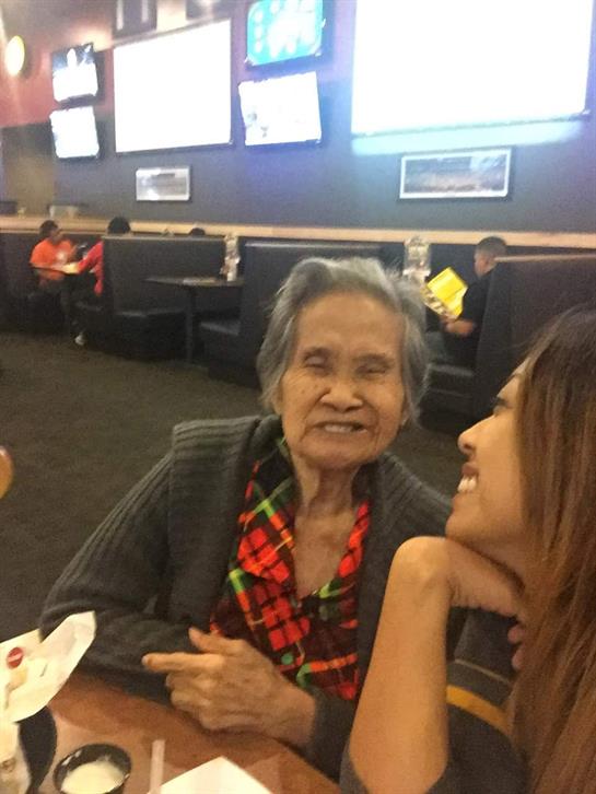 Two women enjoy a joyful interaction at a busy restaurant, surrounded by other diners.