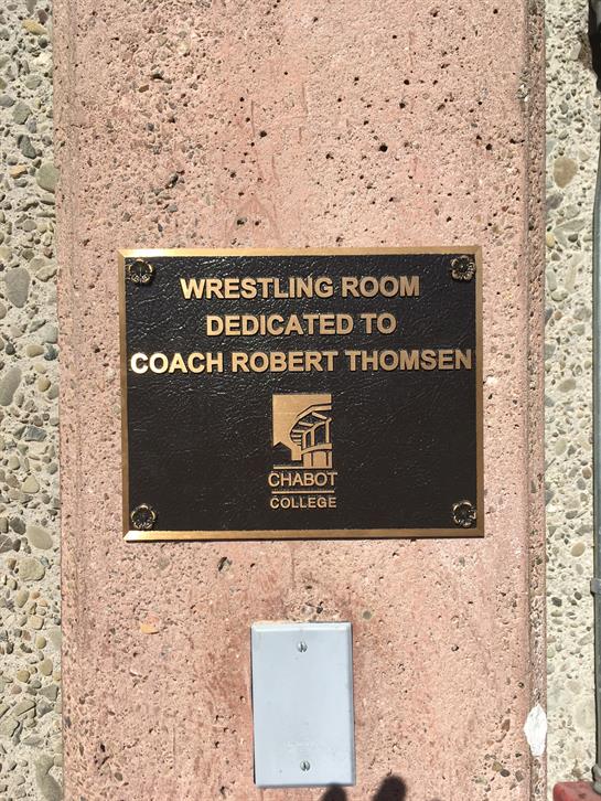 A commemorative plaque honors Coach Robert Thomsen in the wrestling room at Chabot College.