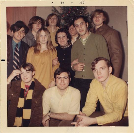 Friends in vintage clothes gather, smiling and posing for a fun memory.