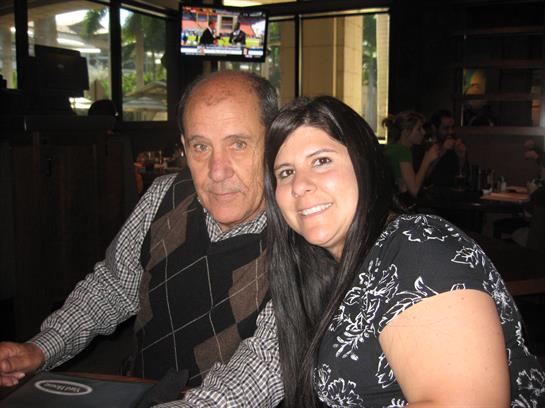 Two people share a joyful moment at a restaurant, smiling happily while seated at a table.