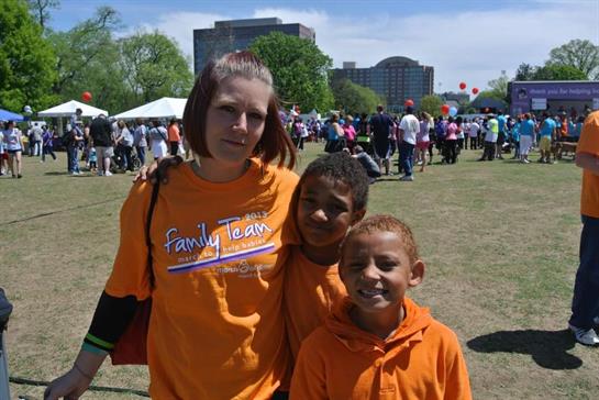 Families gather together at a sunny festival, enjoying activities and entertainment in a park.