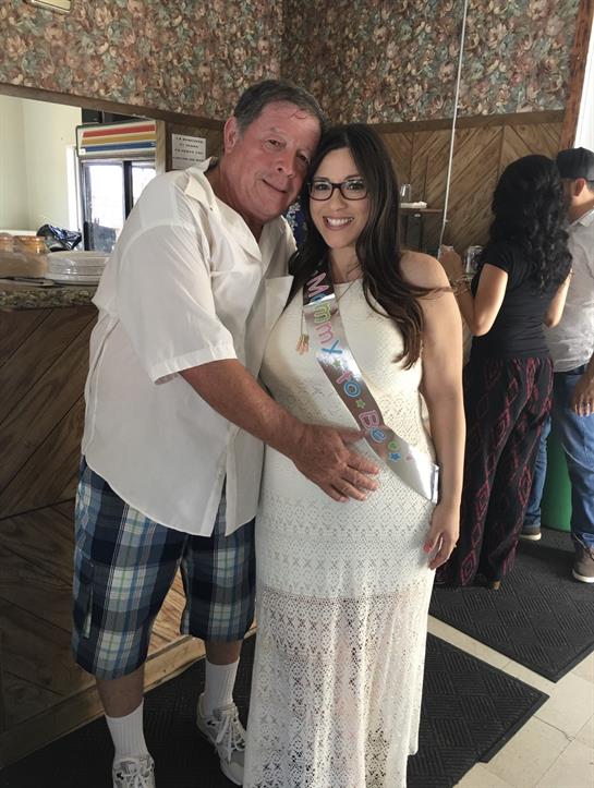 A couple joyfully celebrates their engagement amidst friends in a festive setting.