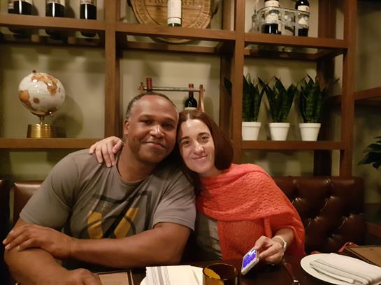 Two friends share a joyful moment at dinner in a warm and inviting eatery.