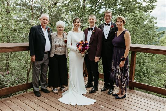 A joyful family gathers for a wedding, showcasing love and delight in a beautiful outdoor setting.