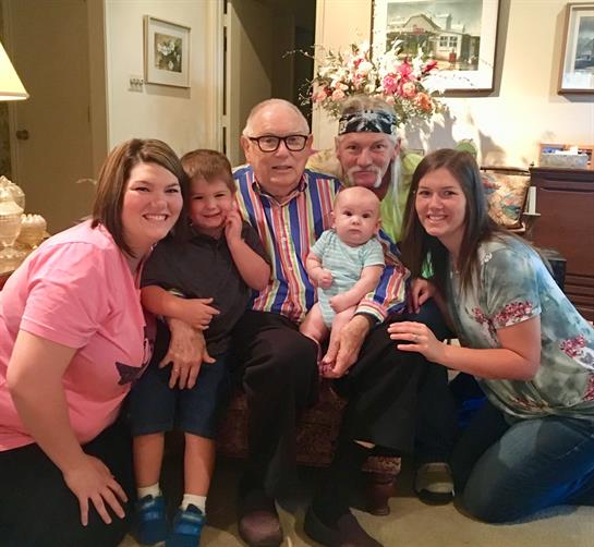 A family is enjoying a heartfelt reunion in a cozy living room setting with children.