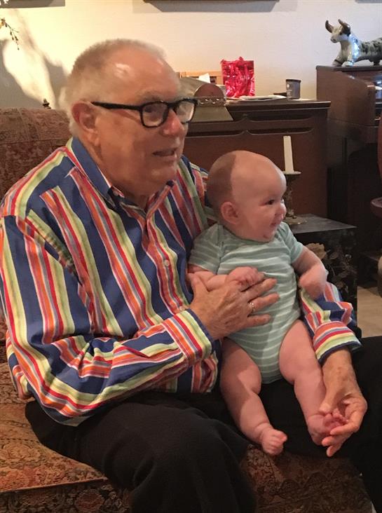 Grandparent enjoys playful interaction with baby, creating memorable family moments together.