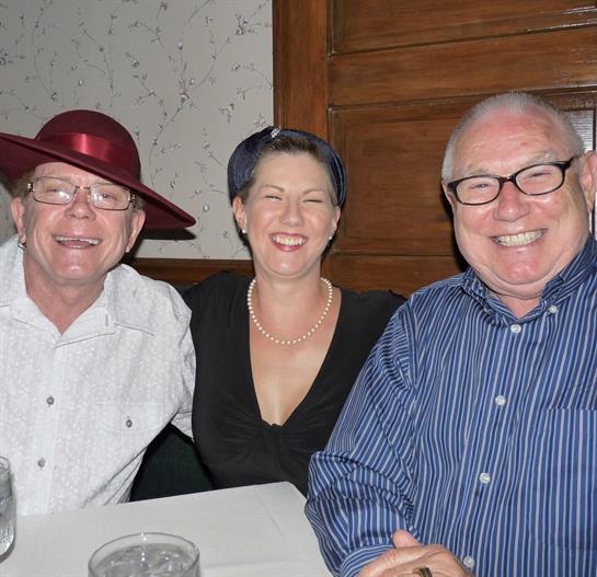 Three friends enjoy laughter and joy at a cozy dinner party, strengthening their bond.