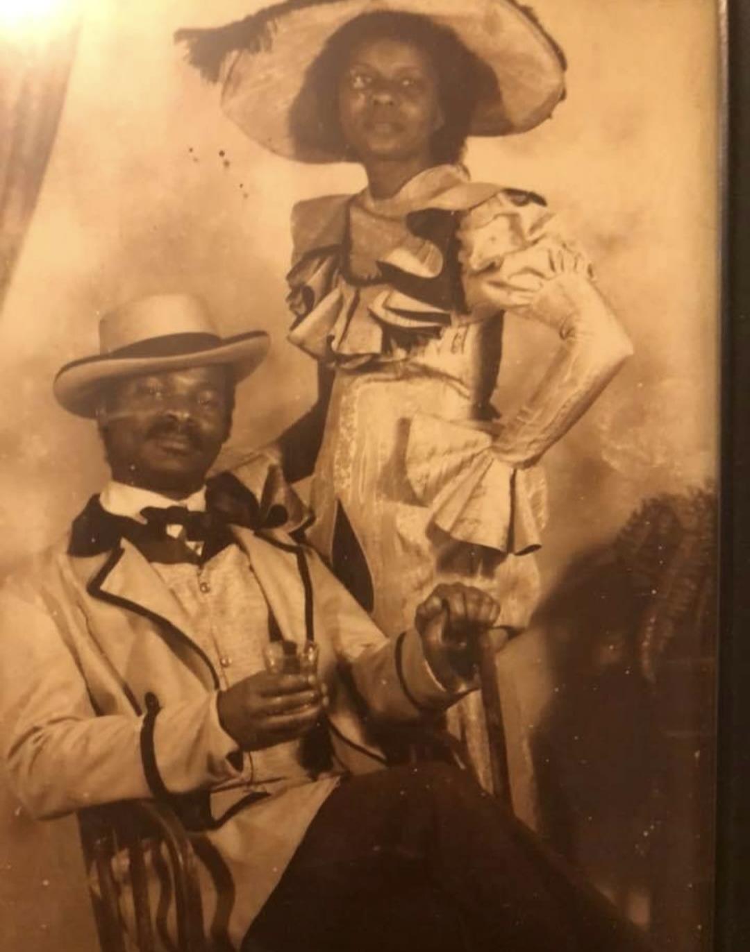 A couple poses in vintage fashionable clothing, showcasing style and elegance from the past.