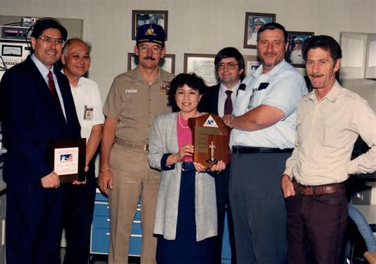 A diverse group poses together after receiving community contribution awards.