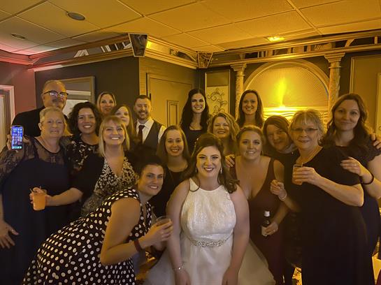 A joyful group of women and men gathered for a wedding celebration in a stylish venue.