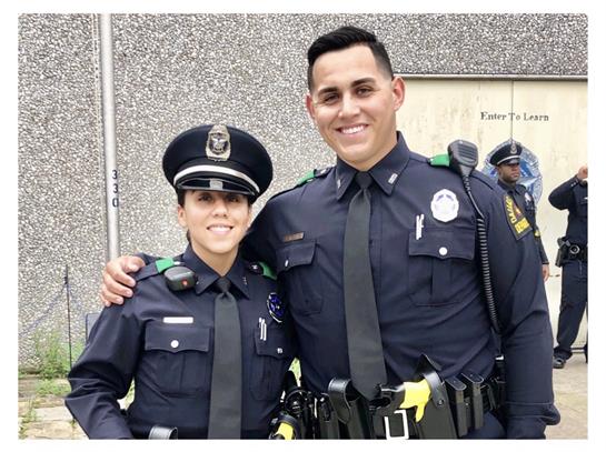 Officers smile in uniform, promoting community engagement at an event.