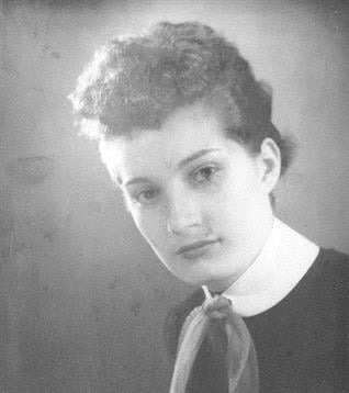 Woman poses for a formal portrait, highlighting vintage fashion and timeless beauty.