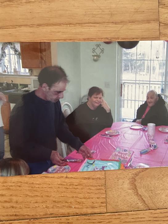 People gathered at a table engaging in conversation while enjoying their food during a celebration.